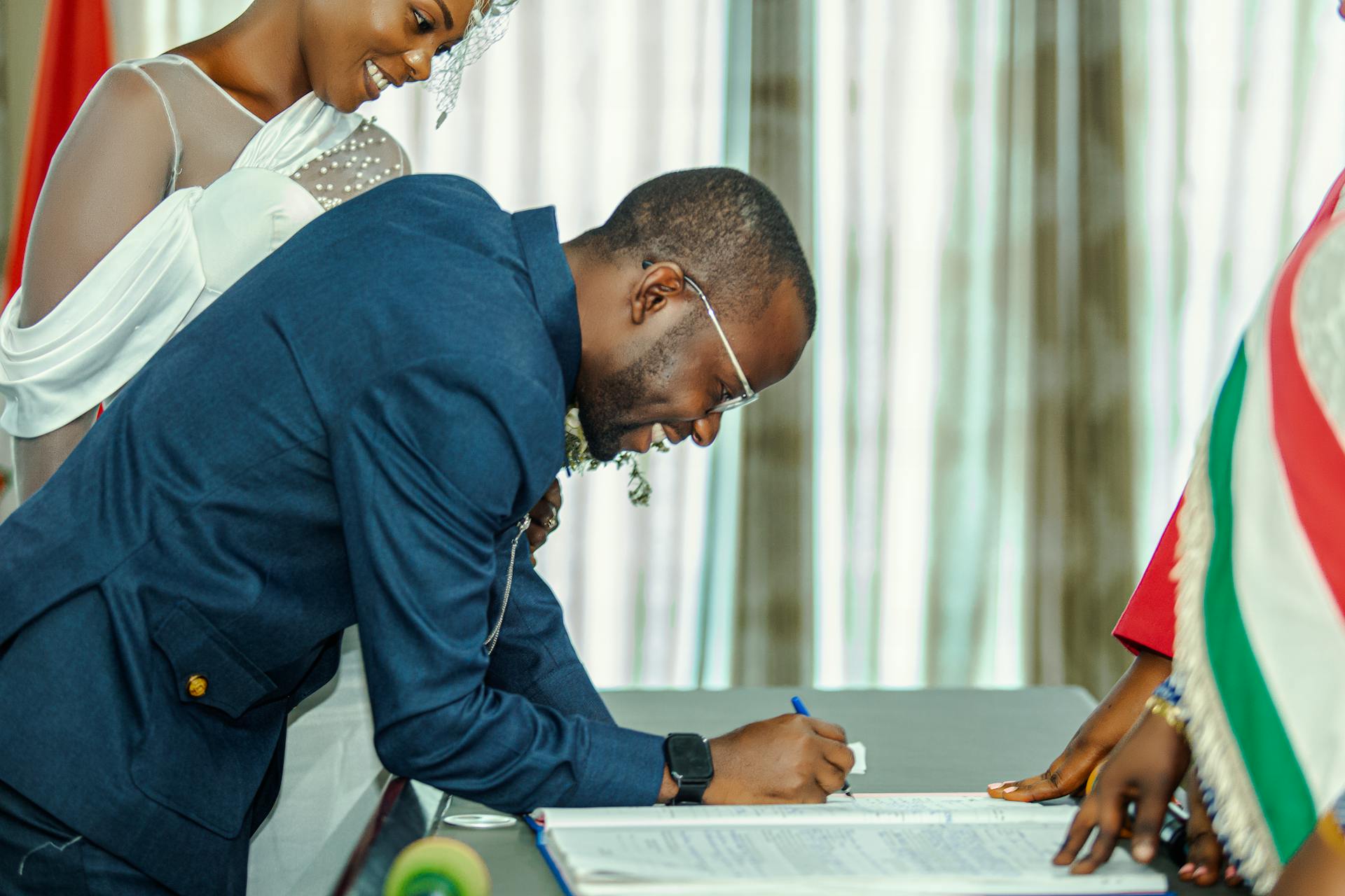 Wedding Planner vs. Wedding Agency: What's the Difference? 5 Bride and groom signing wedding documents