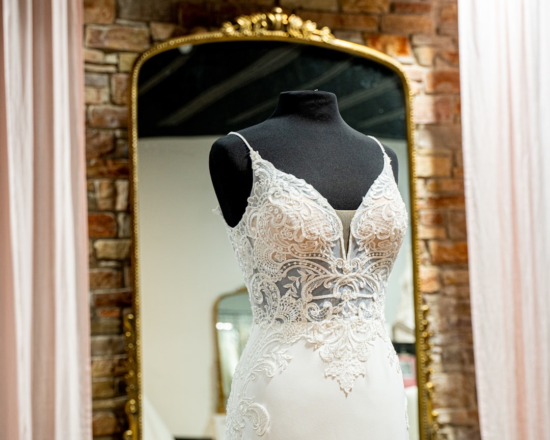 The 12-Month Wedding Planning Timeline: What to Do Every Month From Yes to I Do 3 Bride trying on wedding dress at bridal boutique with consultant