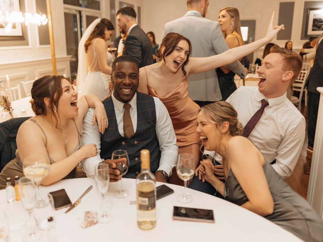 Wedding guests sharing laughter and toasting at intimate reception dinner